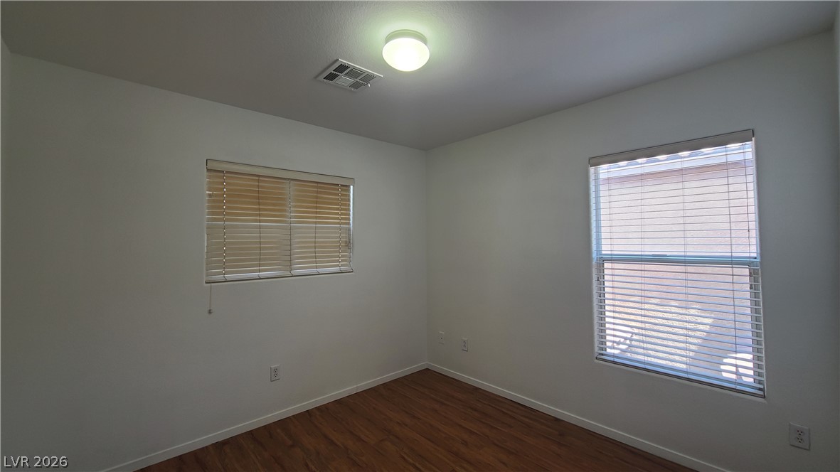8944 Rutherford Grove Street Las Vegas, NV 89148 - Photo 26 of 35 Hardwood-style flooring extends across this modest, well-lit room, featuring two windows with blinds.