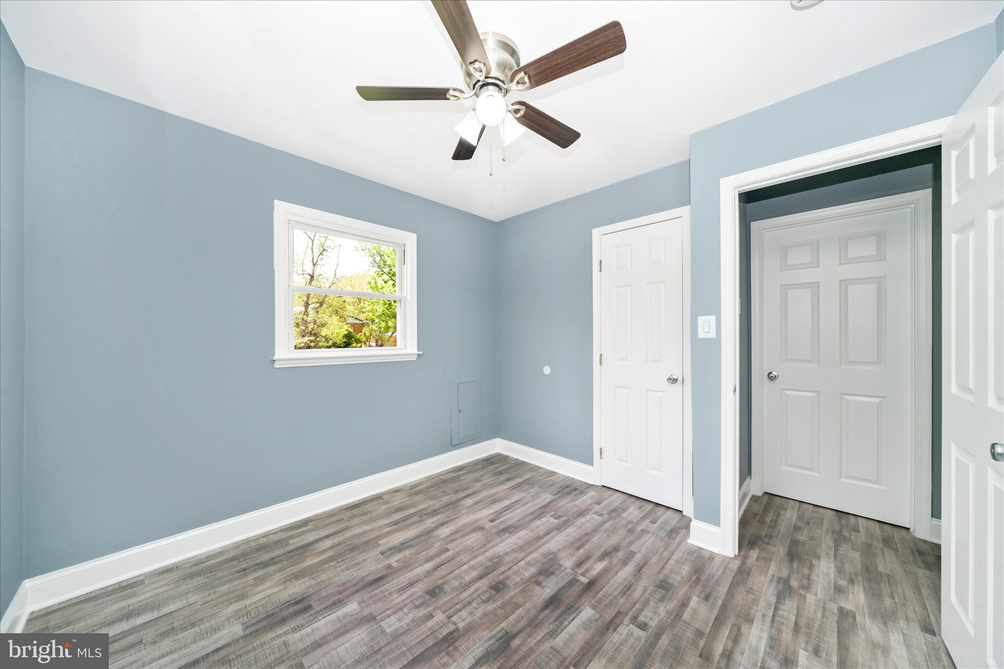 6737 Allentown Road Temple Hills, MD 20748 - Photo 39 of 51 an empty room with wooden floor ceiling fan and windows