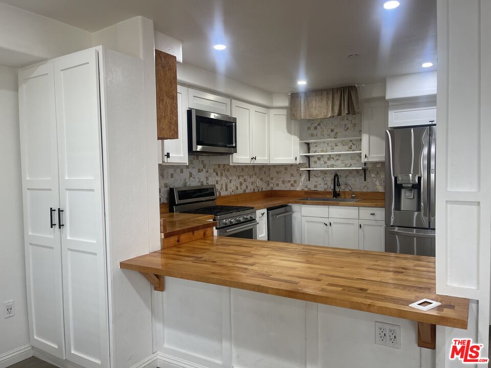 1401 Lomita Boulevard, Unit 205 Harbor City, CA 90710 - Photo 11 of 19 a kitchen with stainless steel appliances granite countertop a sink and a stove top oven
