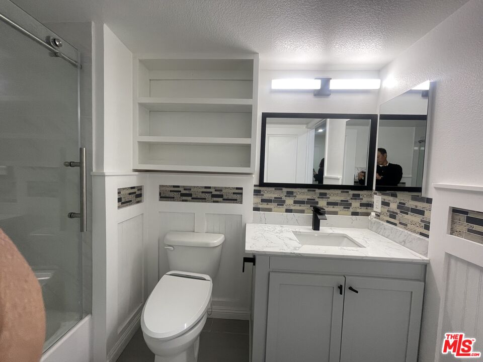 1401 Lomita Boulevard, Unit 205 Harbor City, CA 90710 - Photo 14 of 19 a bathroom with a toilet sink vanity and mirror