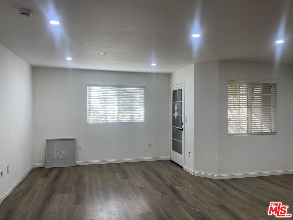 1401 Lomita Boulevard, Unit 205 Harbor City, CA 90710 - Photo 8 of 19 an empty room with wooden floor and windows