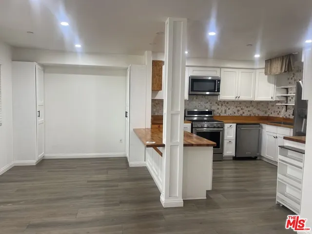 a kitchen with white cabinets and refrigerator