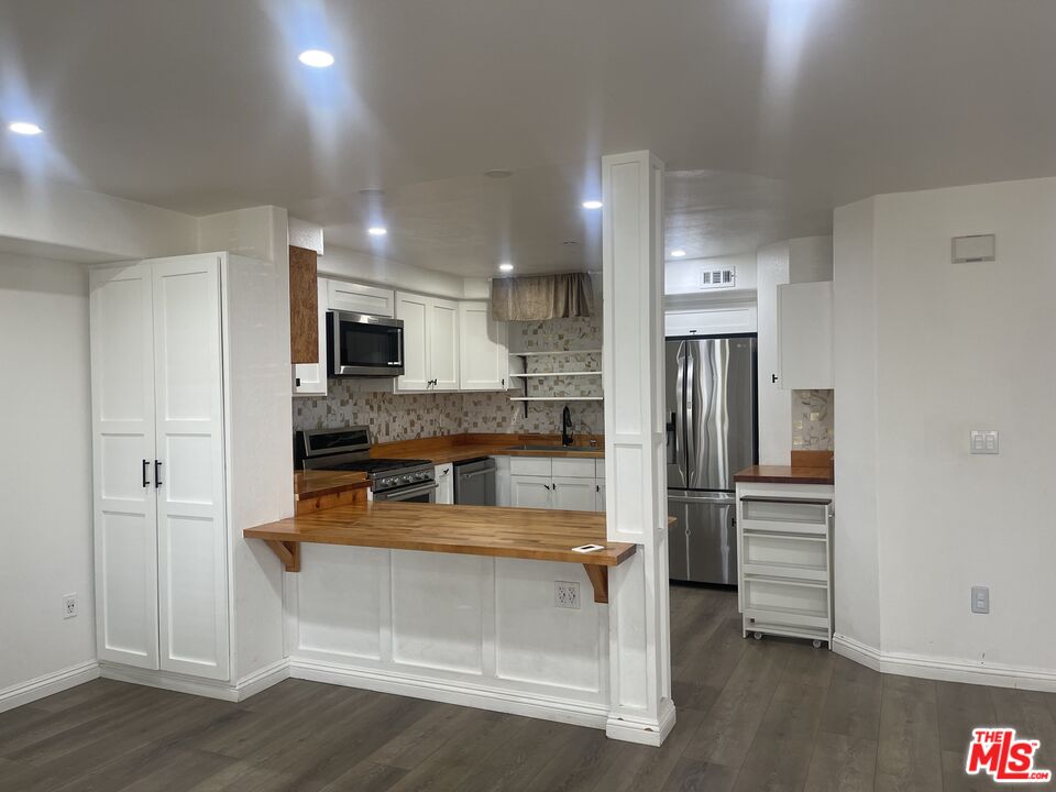 1401 Lomita Boulevard, Unit 205 Harbor City, CA 90710 - Photo 10 of 19 a kitchen with white cabinets and refrigerator
