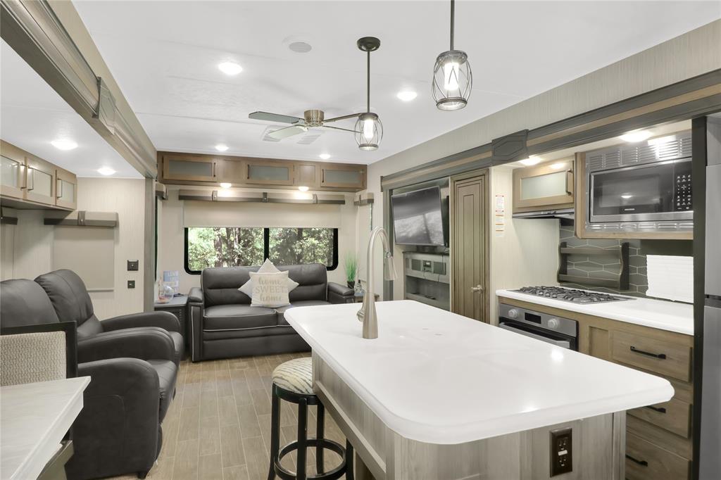 405 Broken Bow Quitman, TX 75783 - Photo 33 of 33 Kitchen featuring open floor plan, hanging light fixtures, light countertops, a breakfast bar, and a ceiling fan