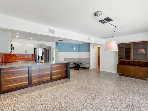 a kitchen with stainless steel appliances kitchen island granite countertop a refrigerator and a stove top oven