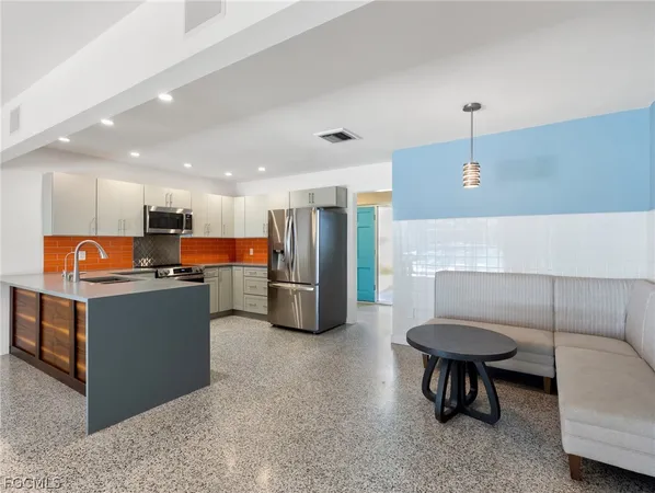 a room with gym equipment and stainless steel appliances