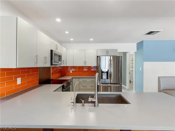 a kitchen with stainless steel appliances granite countertop a refrigerator stove and sink