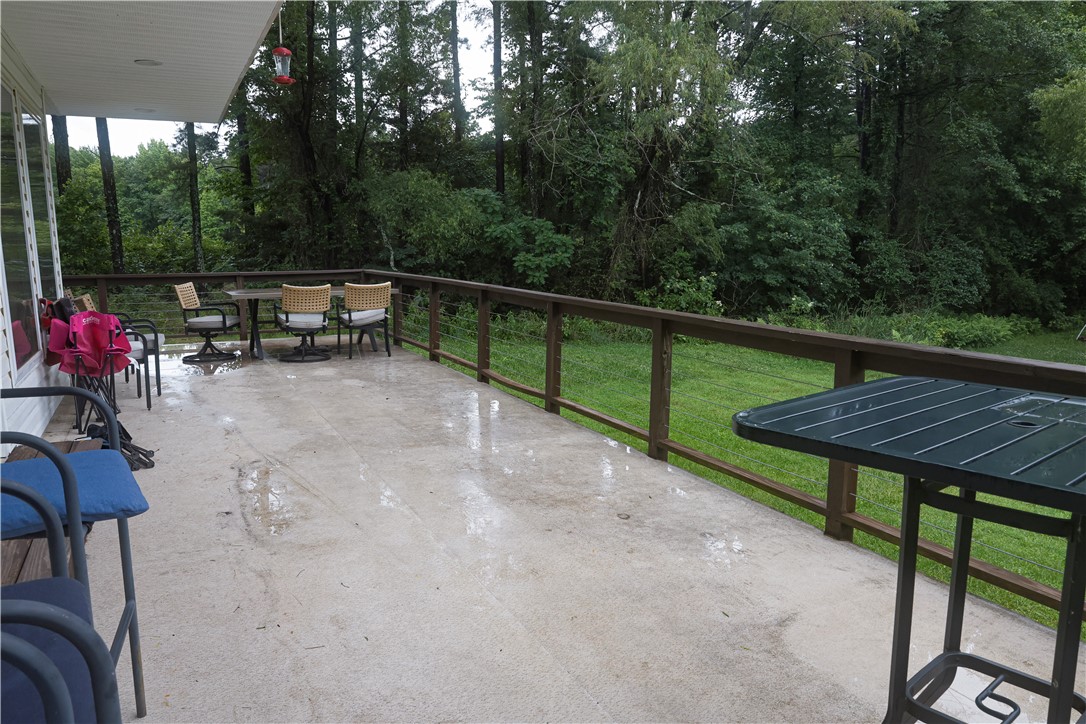 164 Park Road Russellville, AR 72802 - Photo 27 of 35 Expansive outdoor deck featuring a concrete surface, a robust wooden railing, and an overhead awning