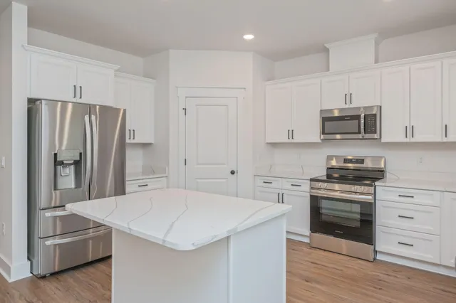 a kitchen with stainless steel appliances a stove microwave and refrigerator