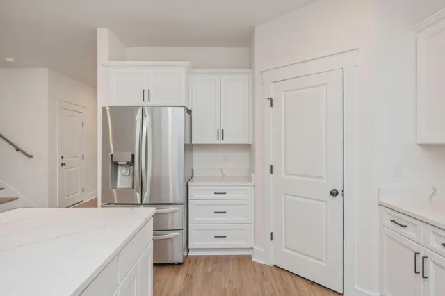 a kitchen with white cabinets and stainless steel appliances
