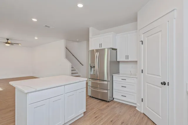 a kitchen with white cabinets and stainless steel appliances