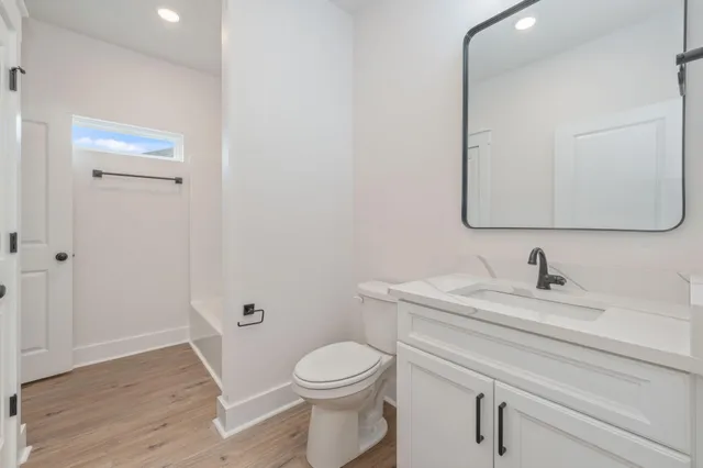 a bathroom with a granite countertop toilet sink and mirror