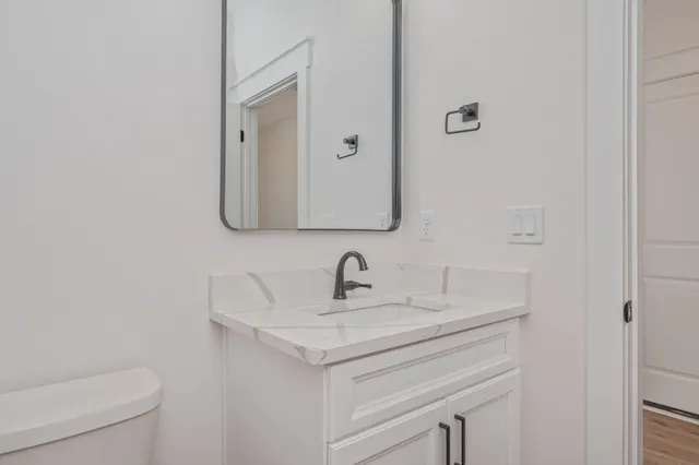 a bathroom with a toilet a sink and mirror