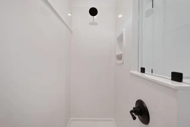 a spacious bathroom with a tub sink and mirror