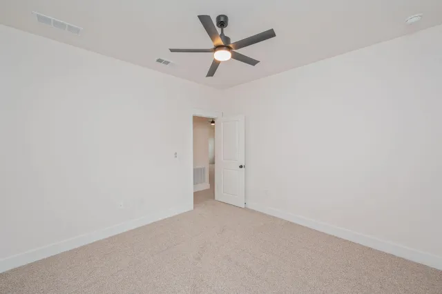 an empty room with window and ceiling fan