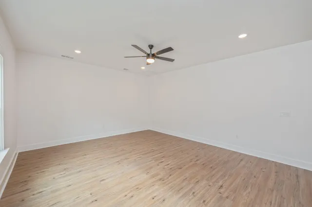 wooden floor in an empty room with a ceiling fan