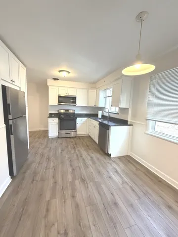 a kitchen with stainless steel appliances a stove a refrigerator and a fireplace