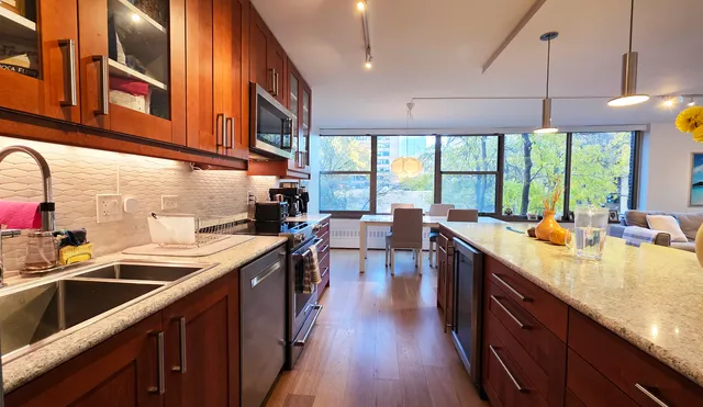a room with stainless steel appliances furniture and a flat screen tv