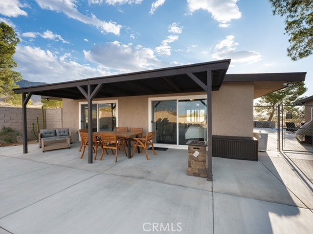 30280 Santa Rosa Road Lucerne Valley, CA 92356 - Photo 5 of 61 a view of a porch with dining table and chairs with a barbeque