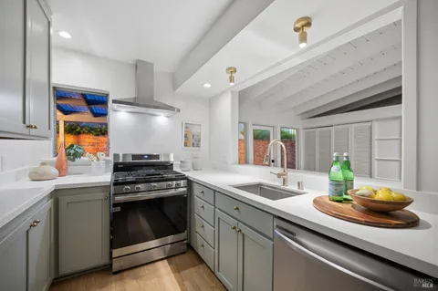 a kitchen with stainless steel appliances a sink a stove and cabinets