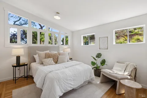 a bedroom with a bed and painting on the wall