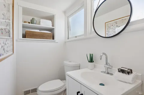 a bathroom with a toilet a sink and a mirror