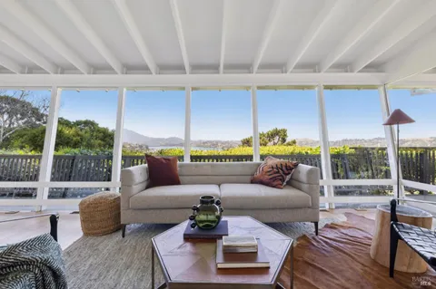 a living room with furniture and a floor to ceiling window