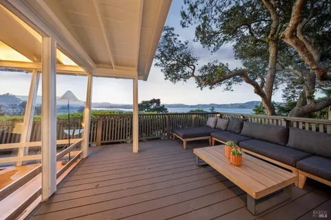 a balcony with wooden floor and outdoor seating