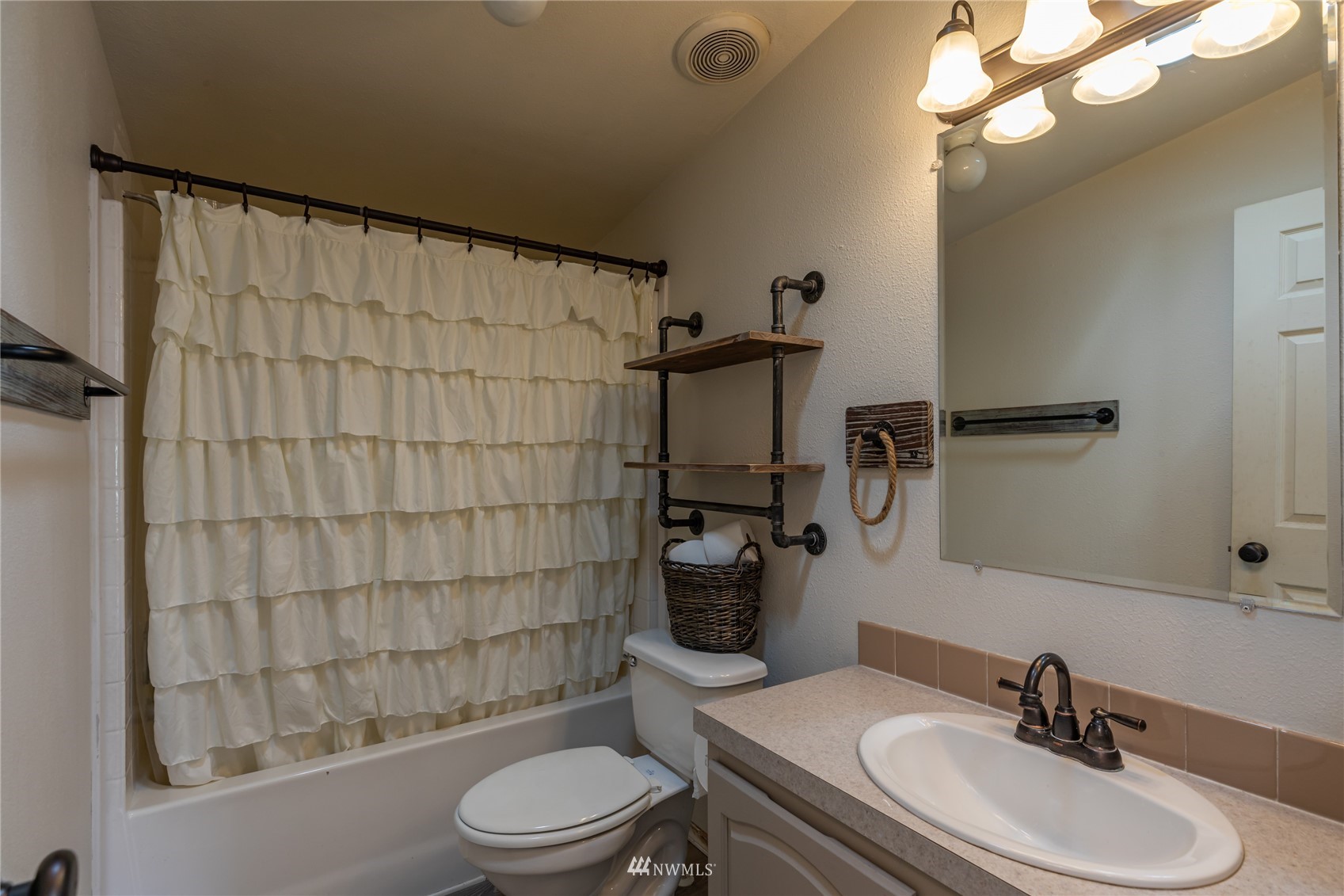 57 Alvarado Road Tonasket, WA 98855 - Photo 14 of 39 a bathroom with a sink toilet a mirror and shower