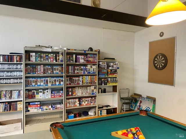 a view of a workspace with bookshelf and a window