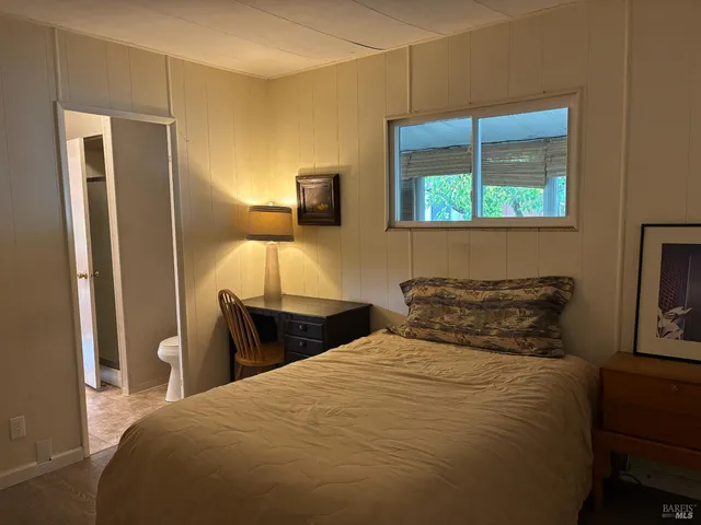 a bedroom with a bed and a potted plant
