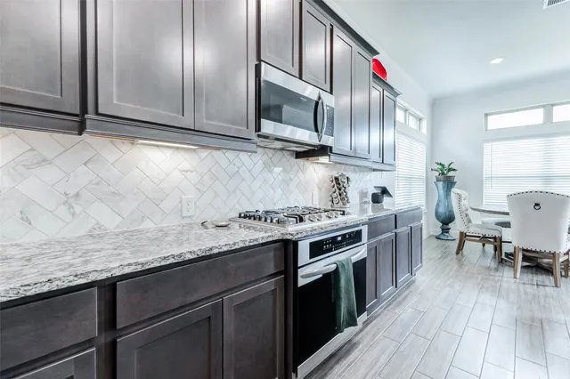 a kitchen with stainless steel appliances granite countertop a sink a stove and cabinets