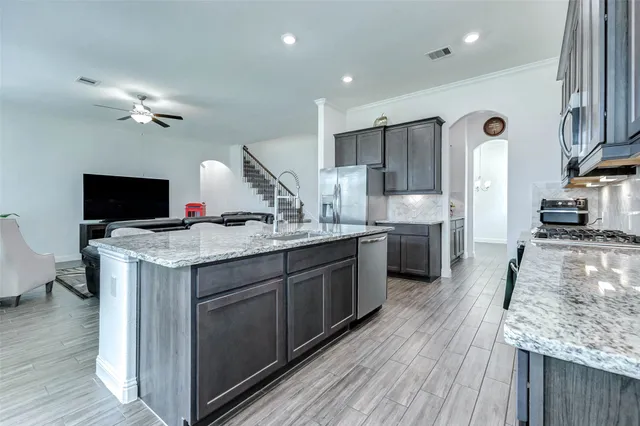 a kitchen with kitchen island granite countertop wooden floor cabinets dining table and chairs
