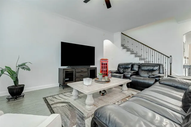 a living room with furniture and a ceiling fan