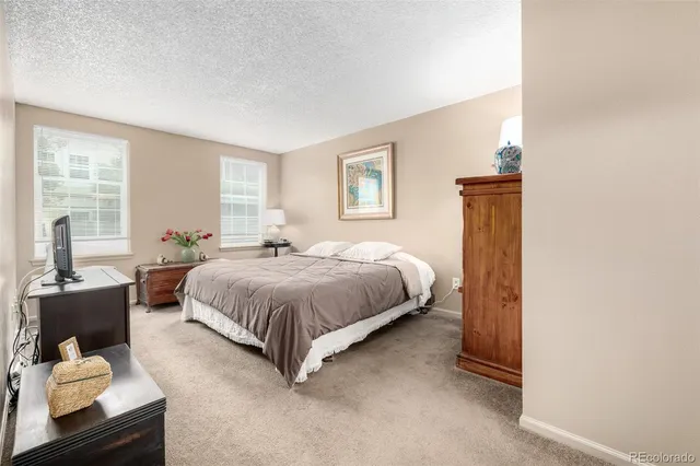 a spacious bedroom with a bed and glass window