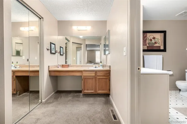 a bathroom with a double vanity sink mirror and toilet