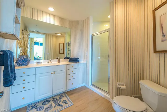 a spacious bathroom with a granite countertop sink toilet and shower