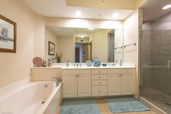 a bathroom with a bathtub a double vanity sink and a mirror
