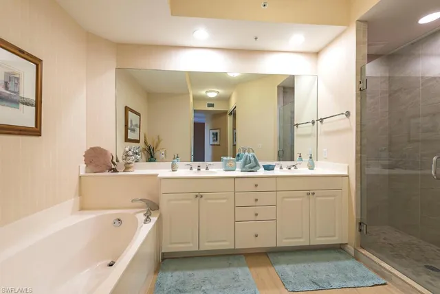 a bathroom with a bathtub a double vanity sink and a mirror