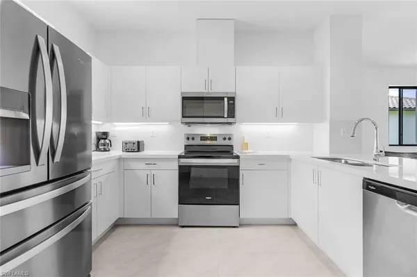 a kitchen with cabinets stainless steel appliances and a sink