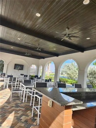 a room with lots of tables a large window and chairs