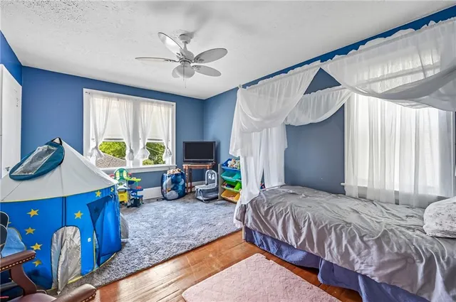 a bedroom with a bed a chandelier and a window