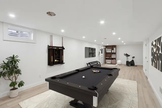 a room with furniture pool table and potted plants