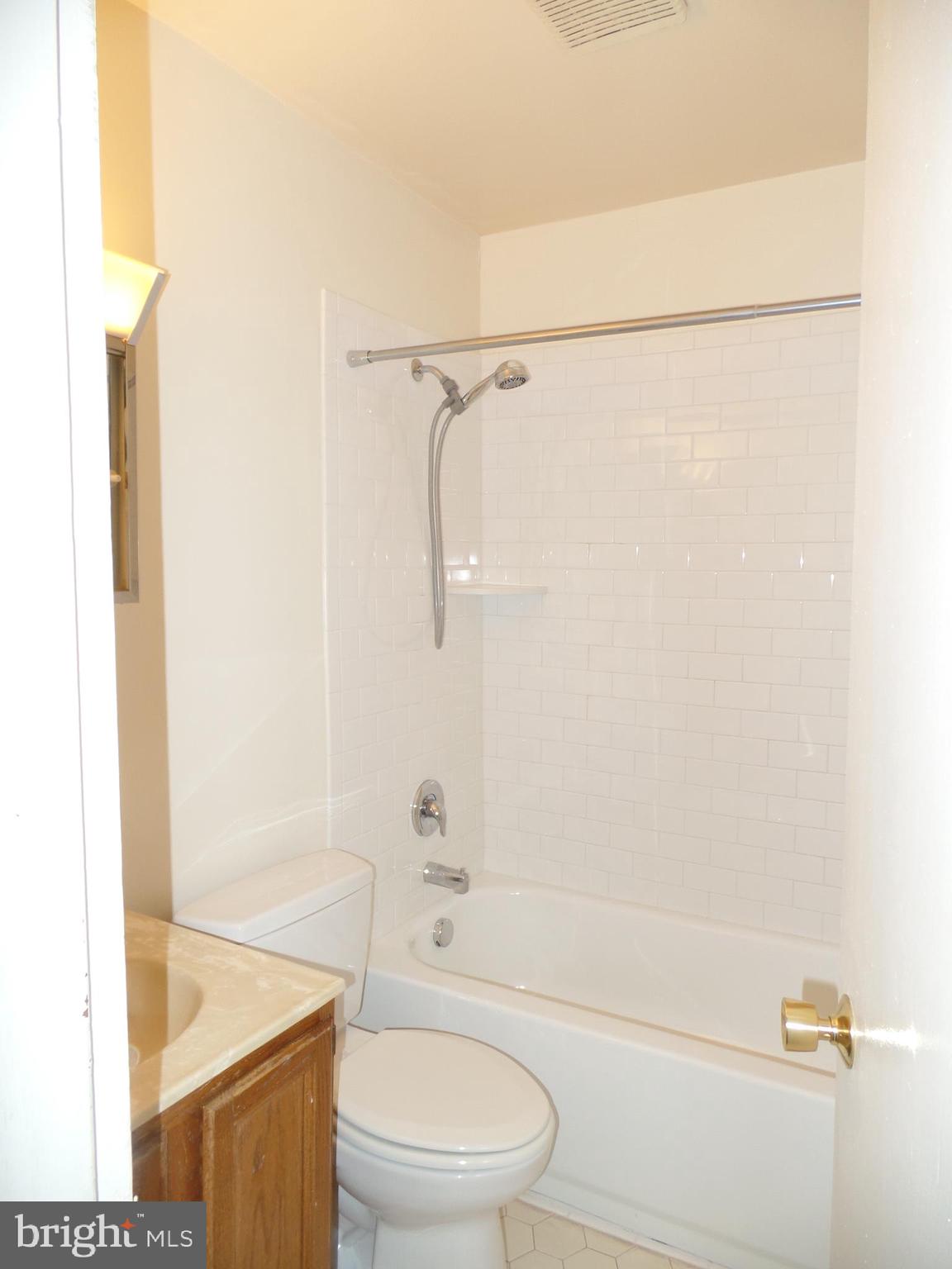 7403 Paxton Road Falls Church, VA 22043 - Photo 8 of 9 a bathroom with a bathtub shower sink vanity and toilet