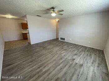 1512 82nd Street, Unit B Lubbock, TX 79423 - Photo 2 of 8 wooden floor in an empty room with a window
