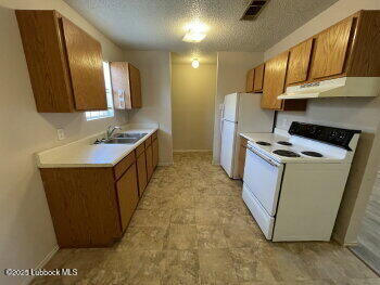 1512 82nd Street, Unit B Lubbock, TX 79423 - Photo 3 of 8 a kitchen with sink a refrigerator and cabinets