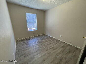 1512 82nd Street, Unit B Lubbock, TX 79423 - Photo 6 of 8 an empty room with wooden floor and windows