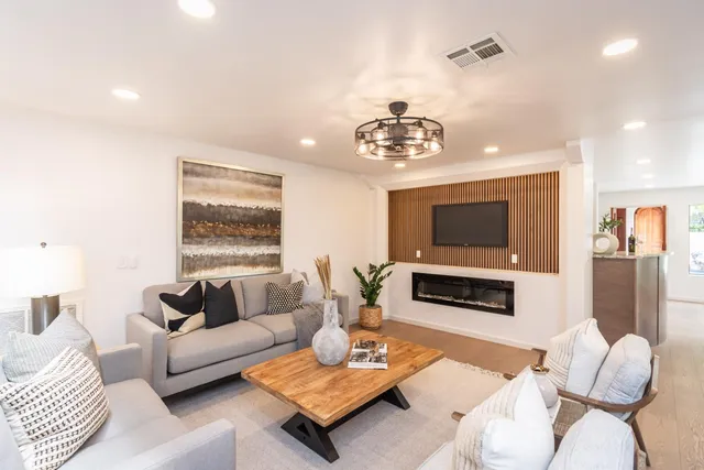 a living room with furniture a flat screen tv and a window