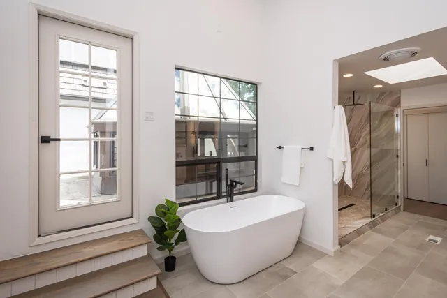 a living room with a bathtub and windows