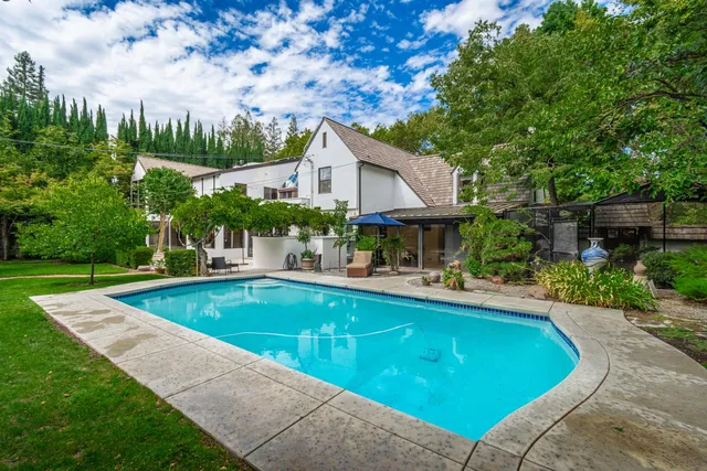 a view of a house with swimming pool and sitting area